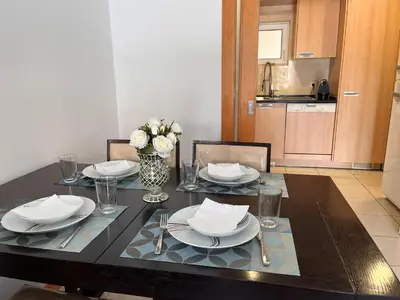 a dining room table with plates and a vase of flowers at Barracuda ByTheSea in Albufeira
