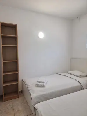a bedroom with two beds and a book shelf at AAA T2 Awesome Albufeira Apartments Piscina Marina in Albufeira