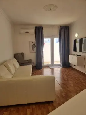a living room with a white couch and a television at AAA T2 Awesome Albufeira Apartments Piscina Marina in Albufeira