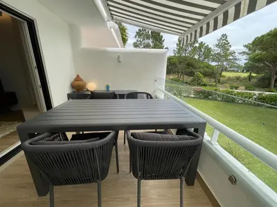 a black table and chairs on a balcony at Victory Village 10C in Quinta do Lago