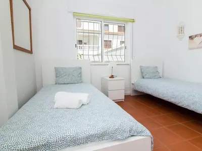a bedroom with two twin beds and a window at Villa Double Joy by Stay ici Algarve Holiday Rental in Albufeira