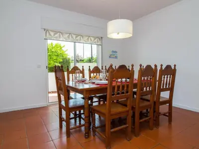 a dining room with a wooden table and chairs at Villa Double Joy by Stay ici Algarve Holiday Rental in Albufeira