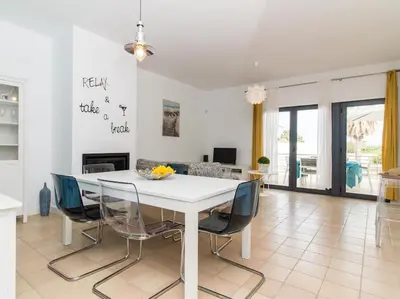 a white dining room with a white table and chairs at Rainbow House by Stay ici Algarve Holiday Rental in Albufeira