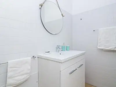 a white bathroom with a sink and a mirror at Rainbow House by Stay ici Algarve Holiday Rental in Albufeira