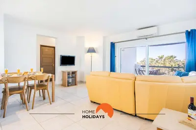 a living room with a yellow couch and a table at #088 T2 São Rafael 64B by Home Holidays in Albufeira