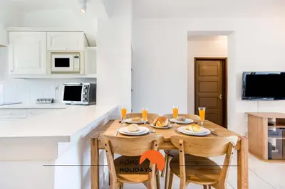 a kitchen with a wooden table and chairs in a kitchen at #088 T2 São Rafael 64B by Home Holidays in Albufeira