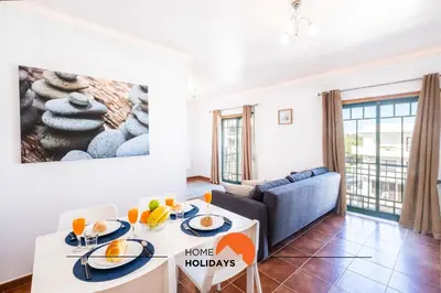 a living room with a couch and a table with food at #020 Medronheira by Home Holidays in Albufeira