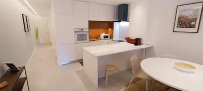 a kitchen with a white counter and a table at 211 Apartamento moderno com vista para a piscina no centro da cidade in Albufeira
