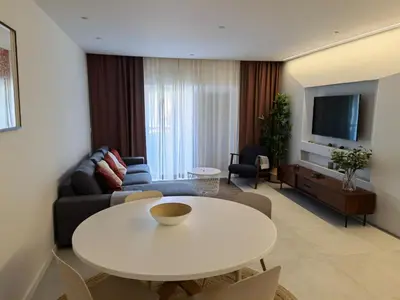 a living room with a white table and a couch at 211 Apartamento moderno com vista para a piscina no centro da cidade in Albufeira