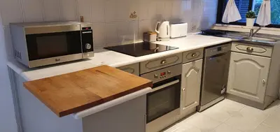 a kitchen with a microwave and a stove top oven at Villa charmosa V2 junto à praia e à Marina de Vilamoura in Quarteira