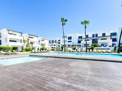 a swimming pool in front of a building with palm trees at FLH Vilamoura Villa Rosa Golf Apartment with Pool in Vilamoura