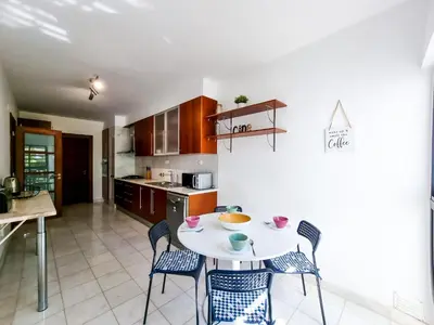 a kitchen with a table and chairs in a room at FLH Vilamoura Villa Rosa Golf Apartment with Pool in Vilamoura