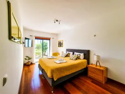 a bedroom with a large bed with a yellow blanket at FLH Vilamoura Villa Rosa Golf Apartment with Pool in Vilamoura