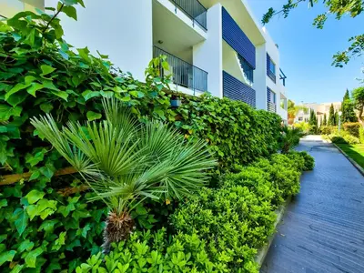 a building with a plant next to a sidewalk at FLH Vilamoura Villa Rosa Golf Apartment with Pool in Vilamoura