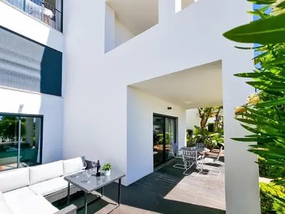 a living room with a white couch and a table at FLH Vilamoura Villa Rosa Golf Apartment with Pool in Vilamoura