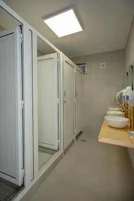 a bathroom with three sinks and a row of mirrors at Sun Lovers Hostel in Albufeira