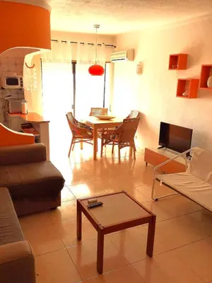 a living room with a couch and a table at 1 Bedroom Apartment Chaves, Praceta Vitorino Nemesio, Albufeira in Albufeira