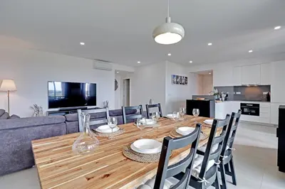 a dining room with a wooden table and chairs at Andiamo Apartment in Vilamoura