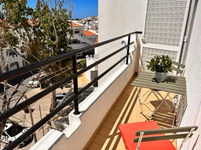 a balcony with a red chair and a plant at City Dacha - Ocean in Albufeira