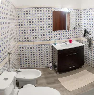 a bathroom with a sink and a toilet and a mirror at City Dacha - Ocean in Albufeira