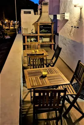 a row of wooden tables and chairs on a patio at Casinha nas Açoteias in Olhos de Água