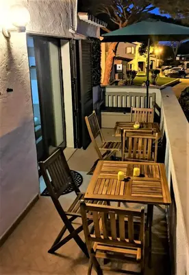 two tables and chairs with an umbrella on a patio at Casinha nas Açoteias in Olhos de Água