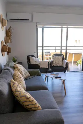 a living room with a couch and two chairs at Beach Loft in Quarteira