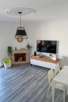 a living room with a television and a table and chairs at Beach Loft in Quarteira