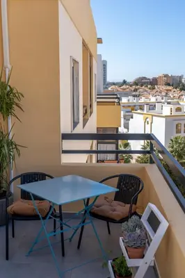 a table and chairs on a balcony with a view at Beach Loft in Quarteira