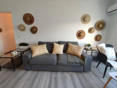 a living room with a couch and some hats on the wall at Beach Loft in Quarteira