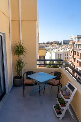 a balcony with a table and chairs on a building at Beach Loft in Quarteira