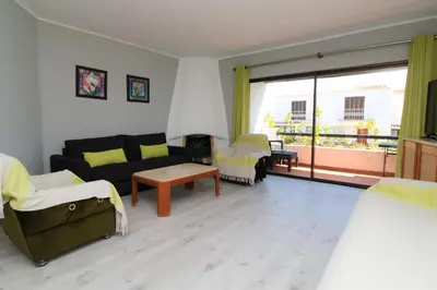 a room with two beds and a couch and a balcony at Apartamento T2 Praia de São Rafael Hibiscus 41A - Albufeira, Algarve in Albufeira