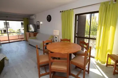 a living room with a table and chairs and a bedroom at Apartamento T2 Praia de São Rafael Hibiscus 41A - Albufeira, Algarve in Albufeira