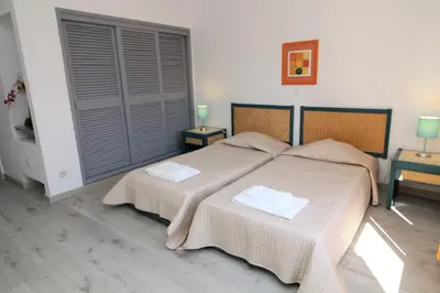 two beds in a bedroom with two tables and two lamps at Apartamento T2 Praia de São Rafael Hibiscus 41A - Albufeira, Algarve in Albufeira