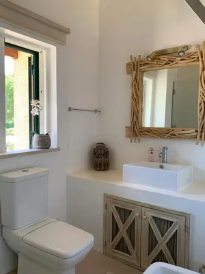 a bathroom with a toilet and a sink and a mirror at Casa de Férias com piscina - Condominio Vilamouraténis in Vilamoura
