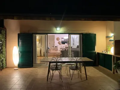 a patio with a table and chairs and a room at Casa de Férias com piscina - Condominio Vilamouraténis in Vilamoura