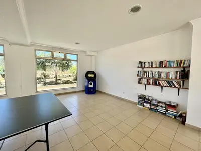 a room with a table and a trash can and a window at Albufeira Terrace With Pool by Homing in Albufeira