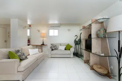 a living room with a blue couch and a table at Marina Views in Quarteira