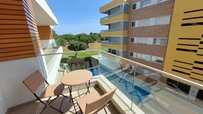 a balcony with two chairs and a table and a building at Forte Novo Beach in Quarteira