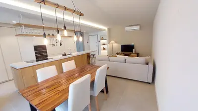 a kitchen and living room with a wooden table and chairs at Forte Novo Beach in Quarteira