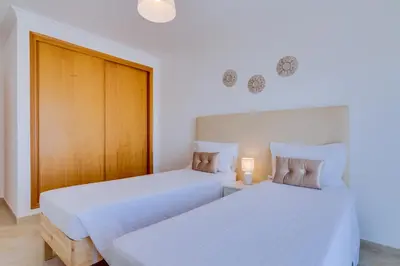 two beds sitting next to each other in a bedroom at AL - Quarteira Old Town in Quarteira