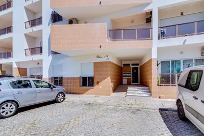 two cars parked in front of a building at AL - Quarteira Old Town in Quarteira