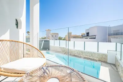 a balcony with chairs and a swimming pool on a building at Atlantis Luxury Villa by Atlantic Places in Albufeira