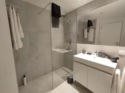 a bathroom with a shower and a sink and a mirror at Sonho Azul in Albufeira