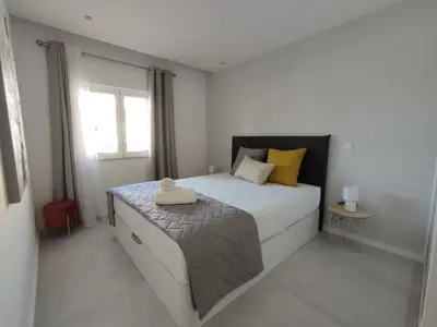 a bedroom with a large bed with yellow pillows at Sonho Azul in Albufeira
