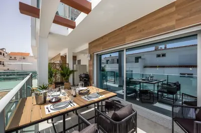 a dining room with a table and chairs on a balcony at Casa Salty in Albufeira