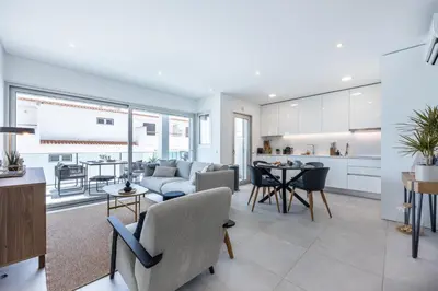 a living room and kitchen with a couch and a table at Casa Salty in Albufeira