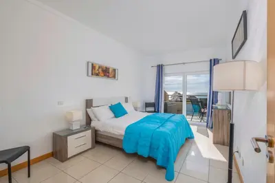 a bedroom with a bed and a view of the ocean at Algarve Beach Apartments in Albufeira
