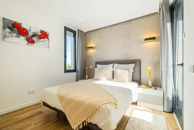 a bedroom with a large white bed and a window at Villa kambolé in Albufeira