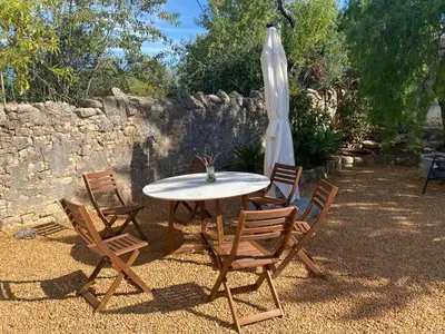 a table with chairs and an umbrella in a yard at Vila Lobo Algarve in Faro